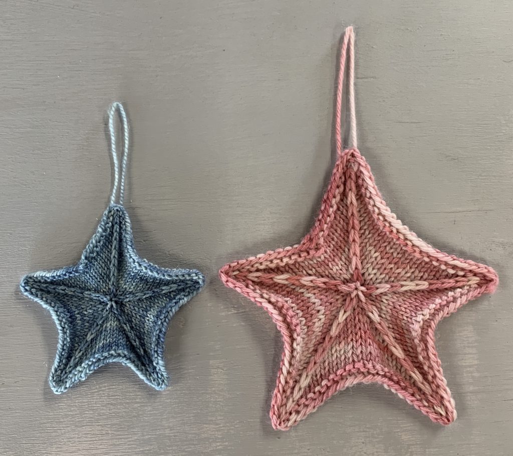 two knit stars - left in 4ply and right in 8ply